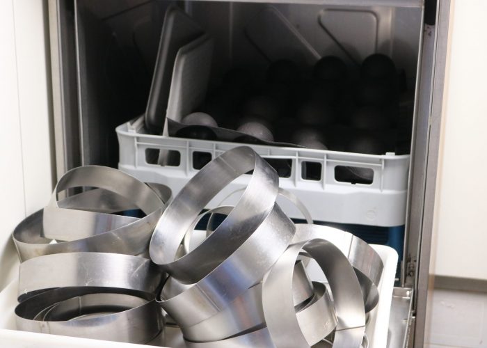 Nettoyage de nos cerclages ayant servi à réaliser nos gâteaux fait-maison dans l'atelier de pâtisserie de la Baguettine du port à Gruissan